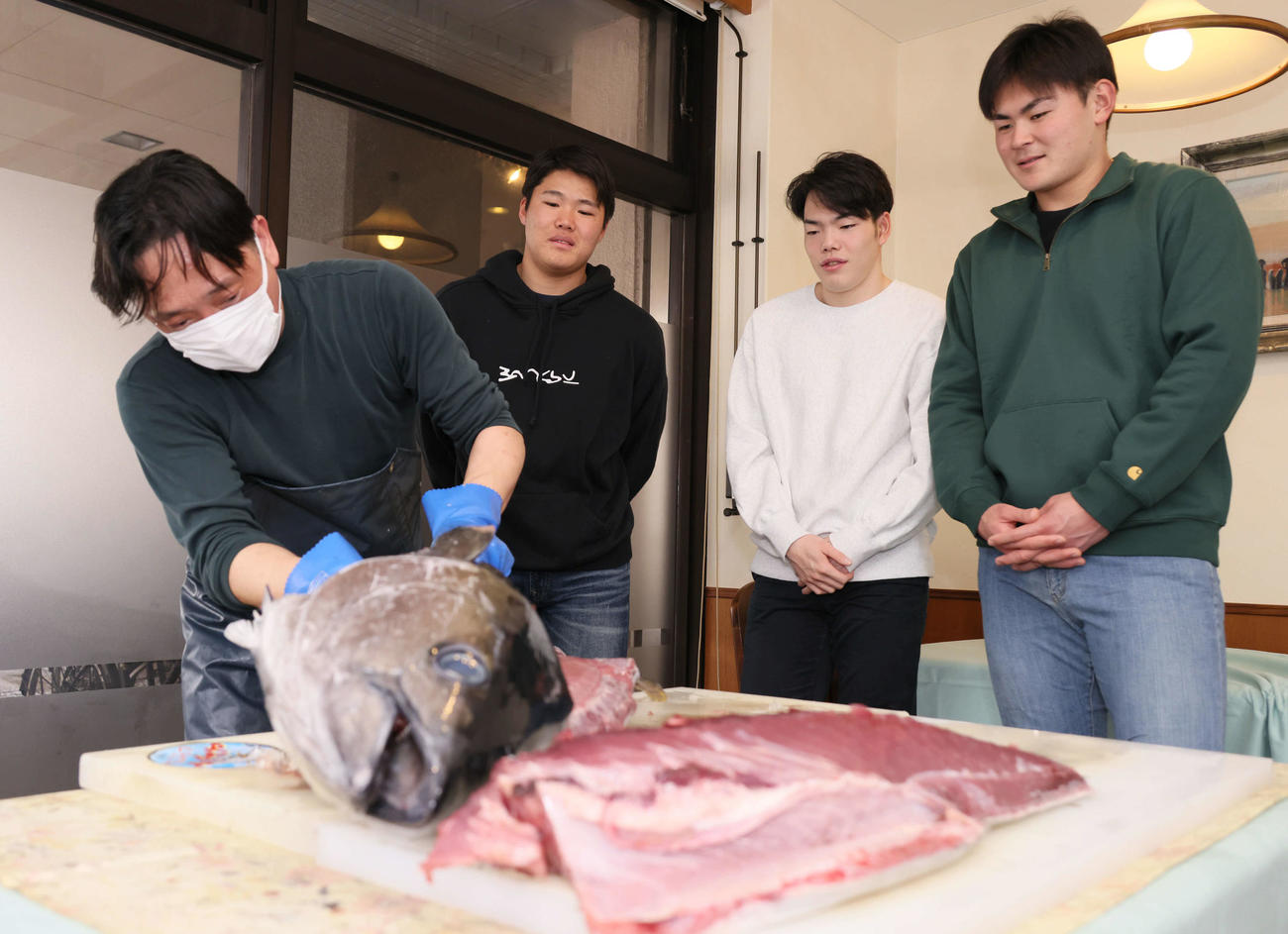 マグロの解体ショーを見学する左2人目から広島ドラフト2位の高、ドラフト3位の滝田、ドラフト5位の赤塚（撮影・加藤孝規）