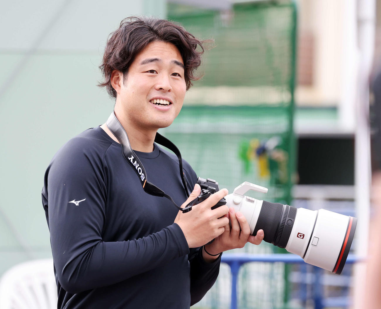 カメラを手に笑顔を見せる楽天滝中（撮影・鈴木正人）