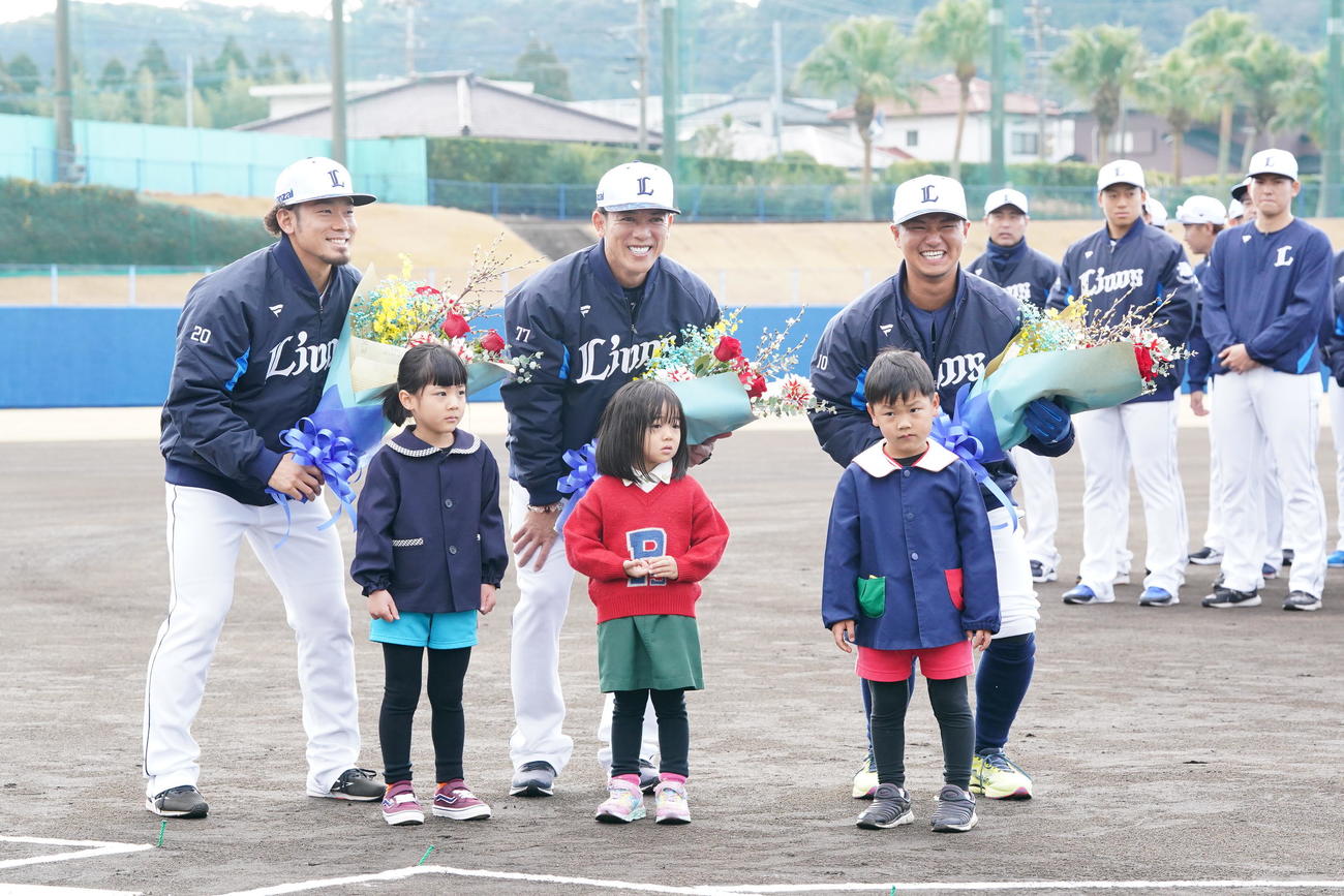 歓迎セレモニーで花束贈呈に臨んだみなと保育園の園児たちと記念撮影する西武の、左から田村、松井監督、佐藤龍（撮影・小沢裕）