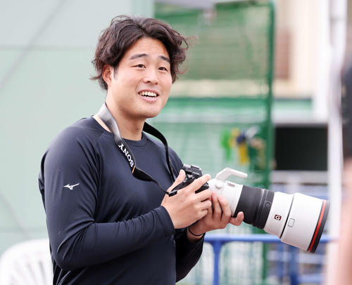 カメラを手に笑顔を見せる楽天滝中（撮影・鈴木正人）