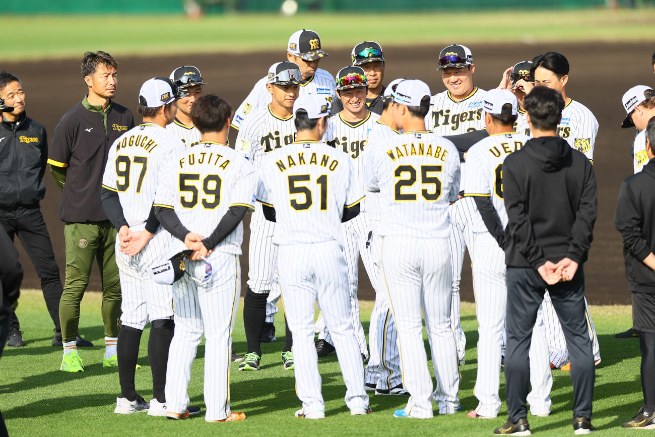 円陣で笑顔を見せる阪神の選手と鳥谷臨時コーチ（左から2人目）（撮影・上山淳一）