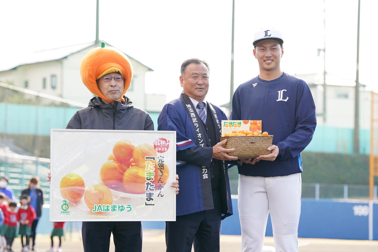 西武南郷キャンプ　歓迎セレモニーで特産品のたまたまを贈呈される西武長谷川（撮影・小沢裕）