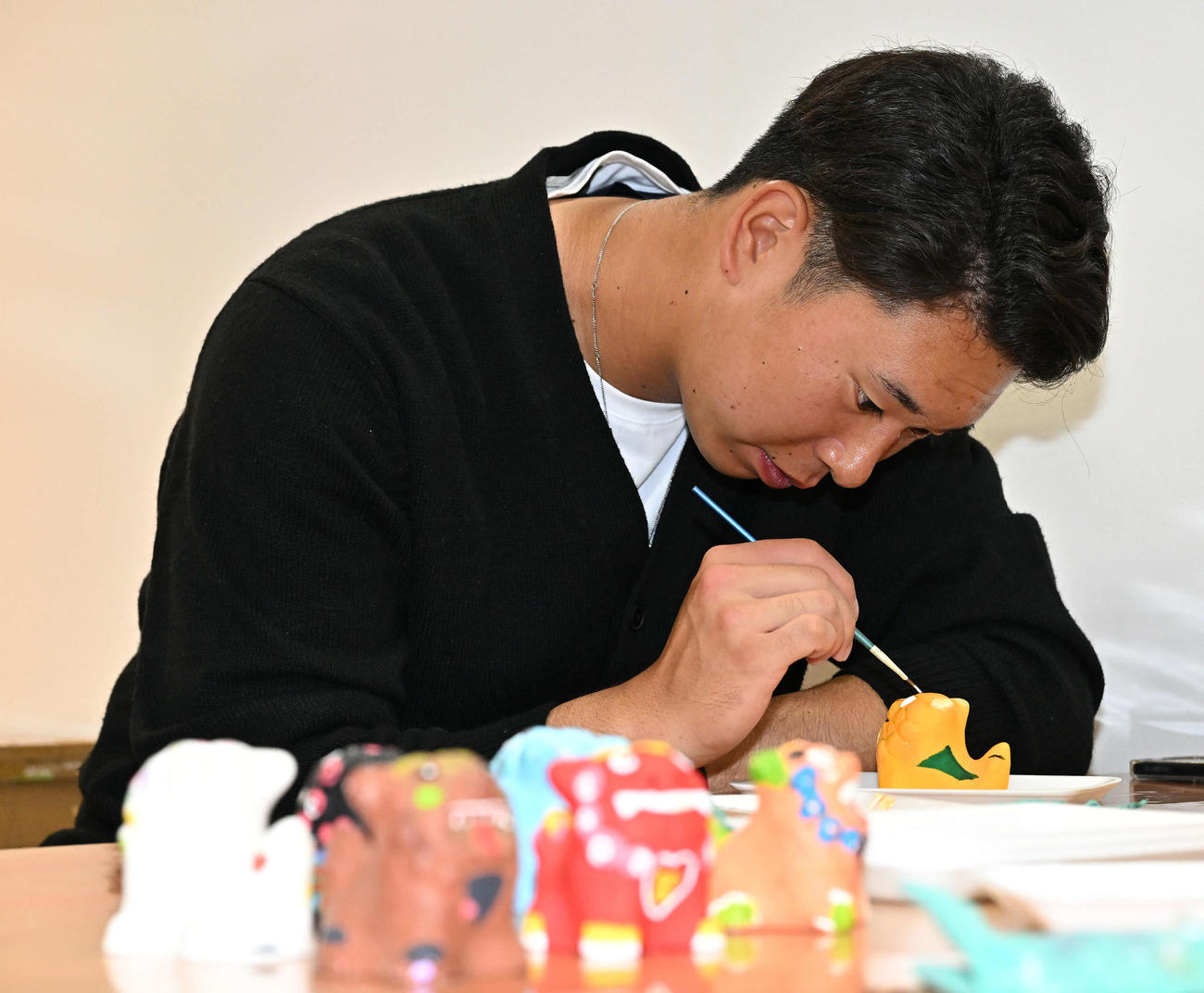 休日に石垣やいま村を訪れシーサーに色を塗るロッテ上田（撮影・滝沢徹郎）