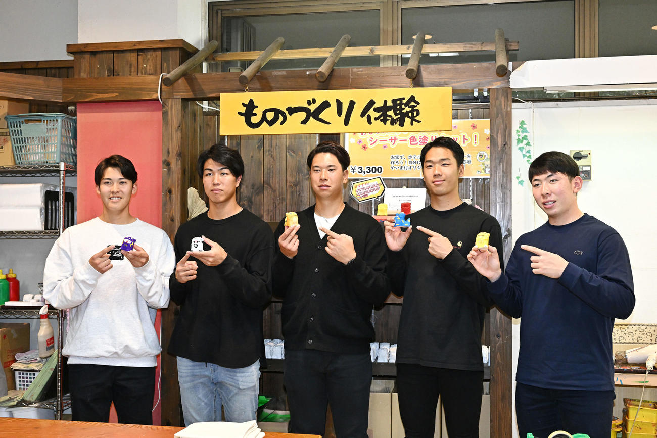 休日に石垣やいま村を訪れ、自身で色を塗ったシーサーを手にするロッテの新人選手たち。左から早坂、大谷、上田、木村、寺地（撮影・滝沢徹郎）