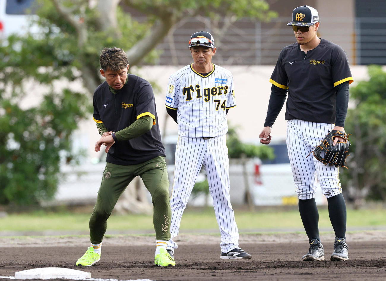 阪神佐藤輝（右）を指導する鳥谷臨時コーチ。中央は藤本内野守備走塁コーチ（撮影・上山淳一）