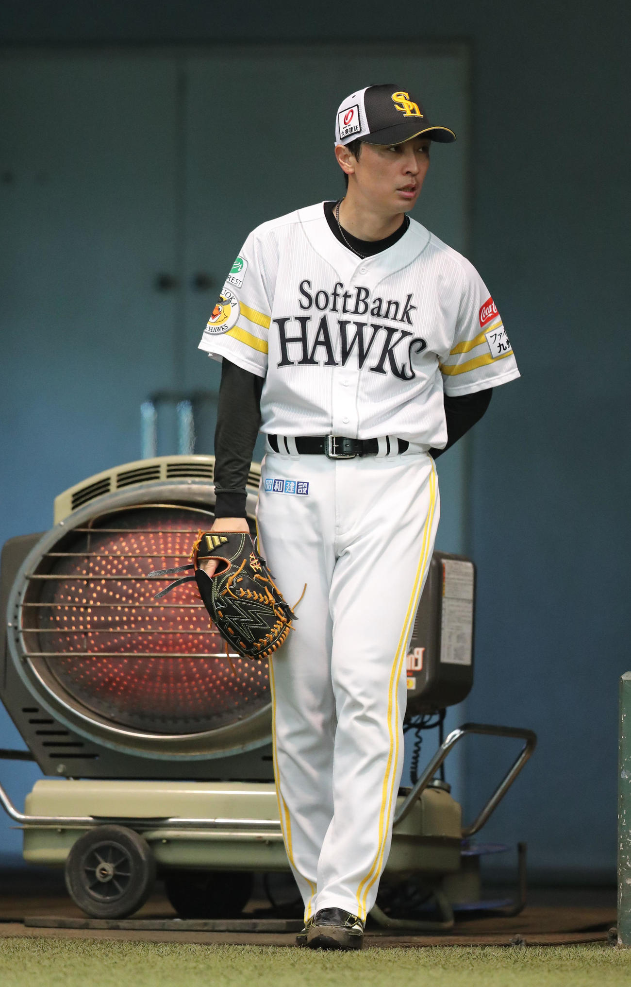 ブルペンで投げ込む前にヒーターで温まる和田（撮影・梅根麻紀）