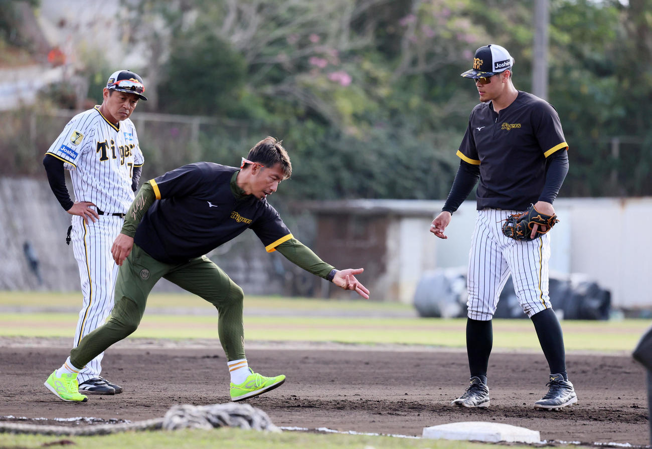 鳥谷臨時コーチとマンツーマンで三塁特守を行った佐藤輝（右）。左は藤本コーチ（撮影・加藤哉）