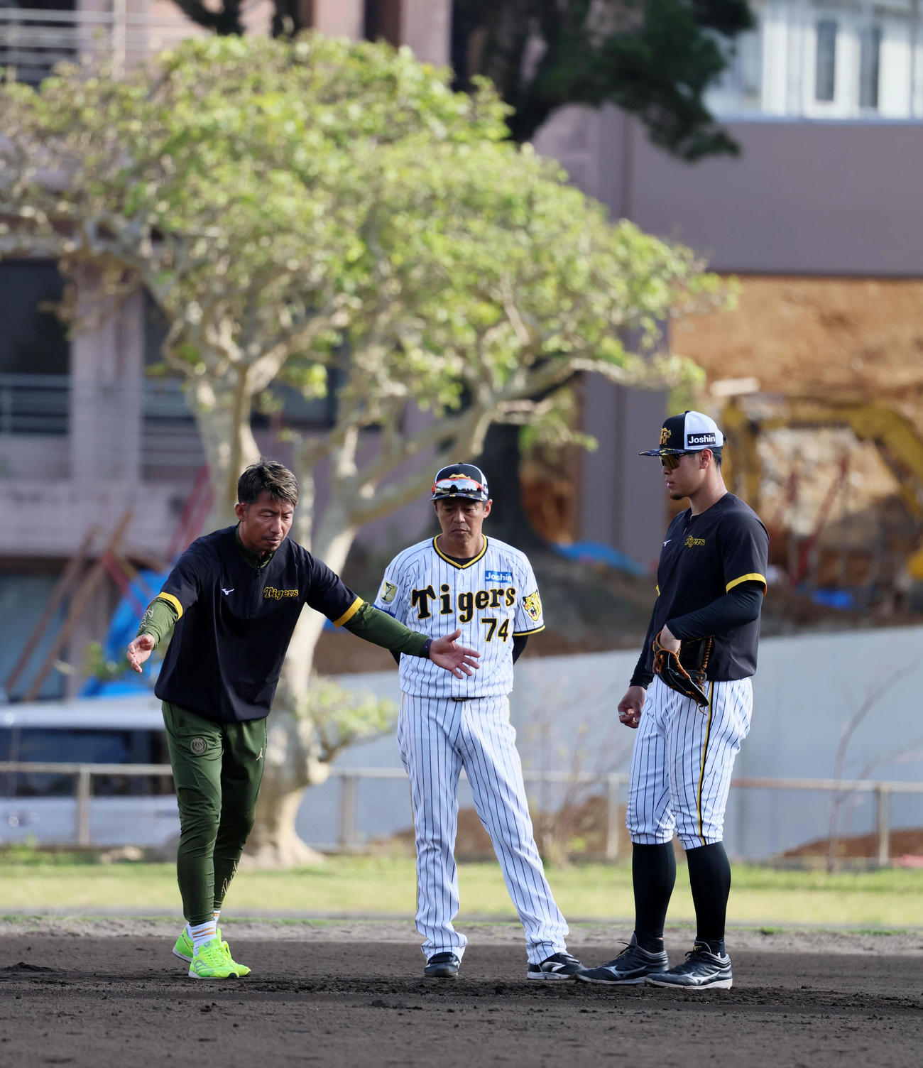 鳥谷臨時コーチは身振りを交え佐藤輝（右）の特守でアドバイスを送る。中央は藤本コーチ（撮影・加藤哉）