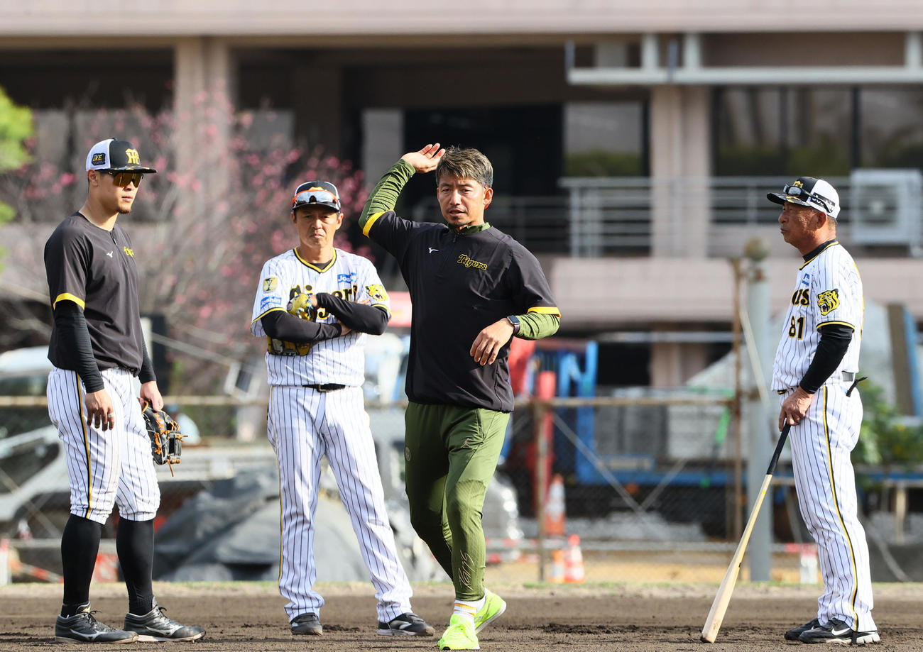 鳥谷臨時コーチ（手前）は阪神佐藤輝（左）を指導する。左から2人目は藤本内野守備走塁コーチ、右は馬場内野守備走塁コーチ（撮影・上山淳一）
