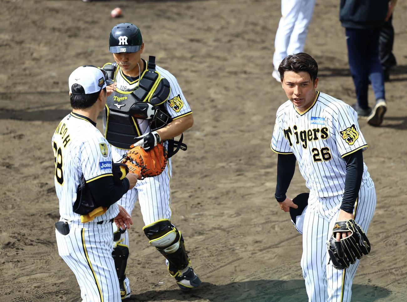 阪神春季キャンプ　打撃投手を終えた、安藤投手コーチ（左）と言葉を交わす椎葉（右）（撮影・藤尾明華）