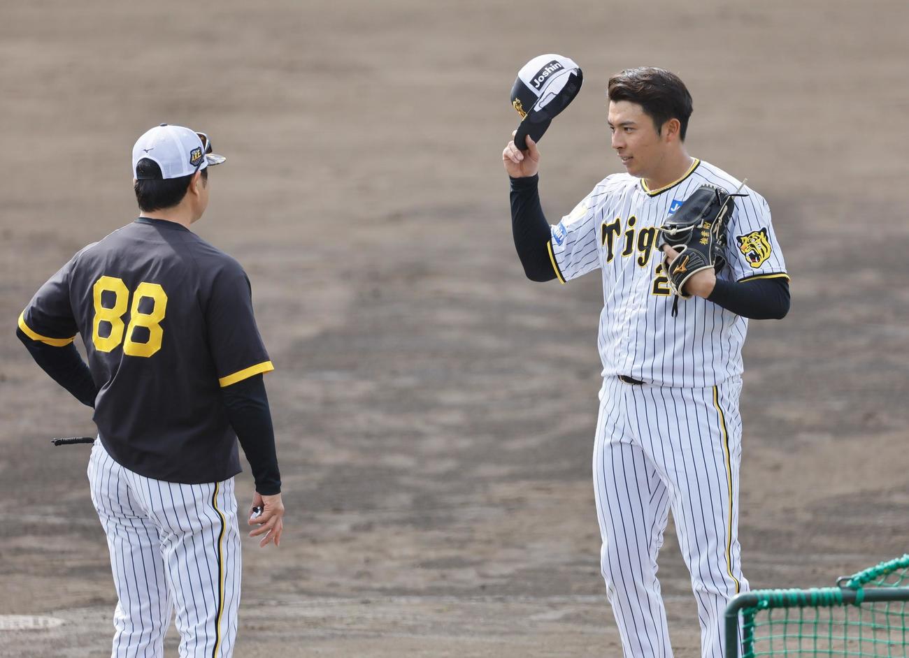 阪神春季キャンプ　打撃投手の前に安藤投手コーチ（左）に声をかけられる椎葉（撮影・藤尾明華）