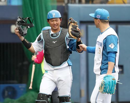 日本ハム紅白戦　4回、引き揚げる生田目（右）とタッチする進藤（撮影・黒川智章）