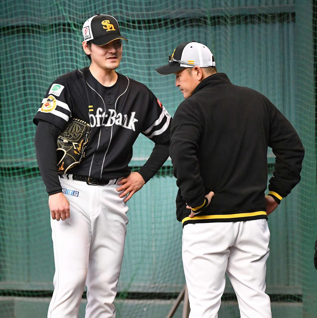 ブルペンでの投球を終えて倉野コーチ（右）と話すソフトバンク有原（撮影・岩下翔太）