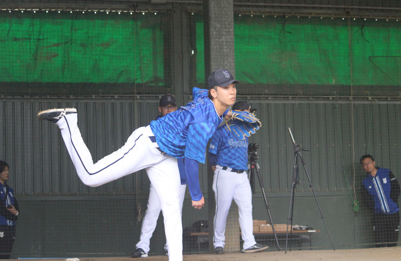 ブルペンでボールを投げ込むDeNA入江。後方は三浦監督（撮影・久保賢吾）