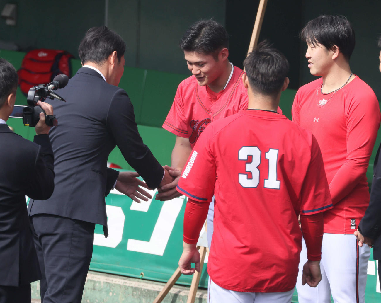 侍ジャパンの井端監督（左）と握手する広島田村。左から3人目は坂倉、同4人目は小園（撮影・加藤孝規）