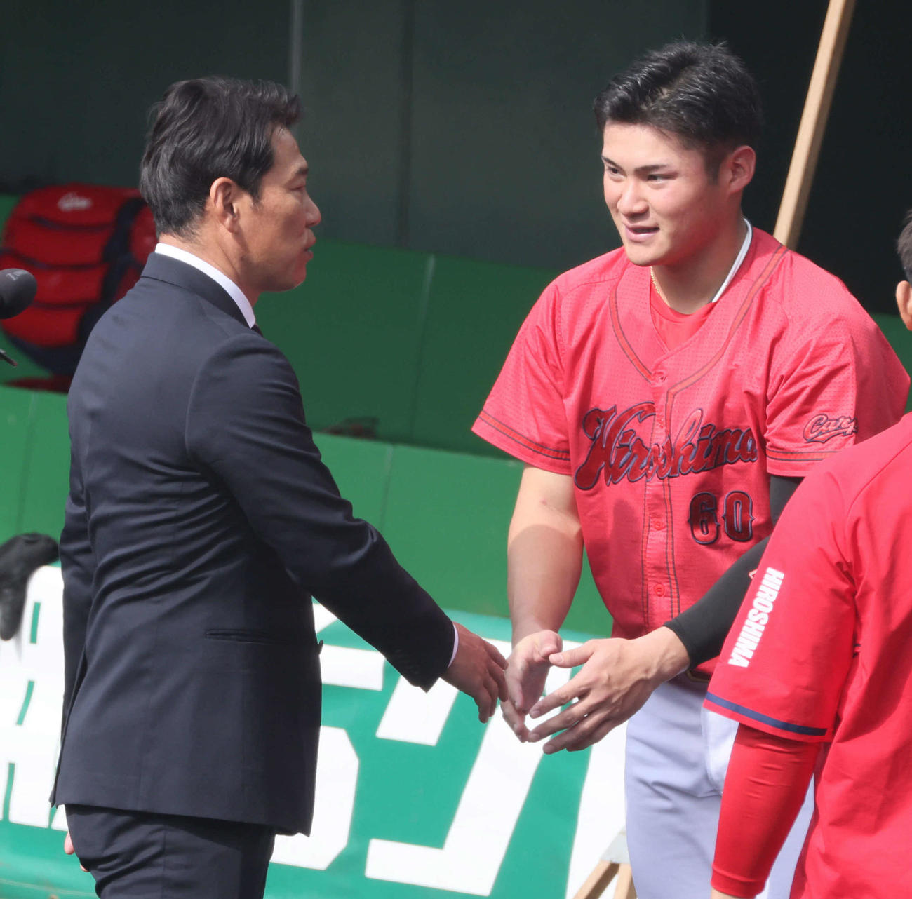 侍ジャパンの井端監督（左）と握手する広島田村（撮影・加藤孝規）