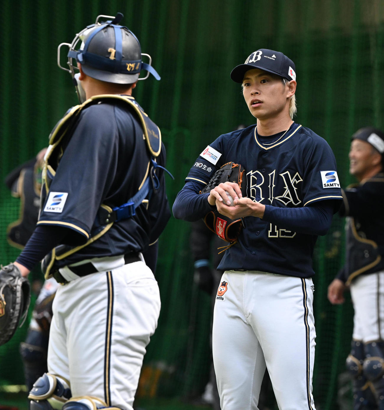 ブルペンでの投球後、森（左）と話すオリックス山岡（撮影・和賀正仁）