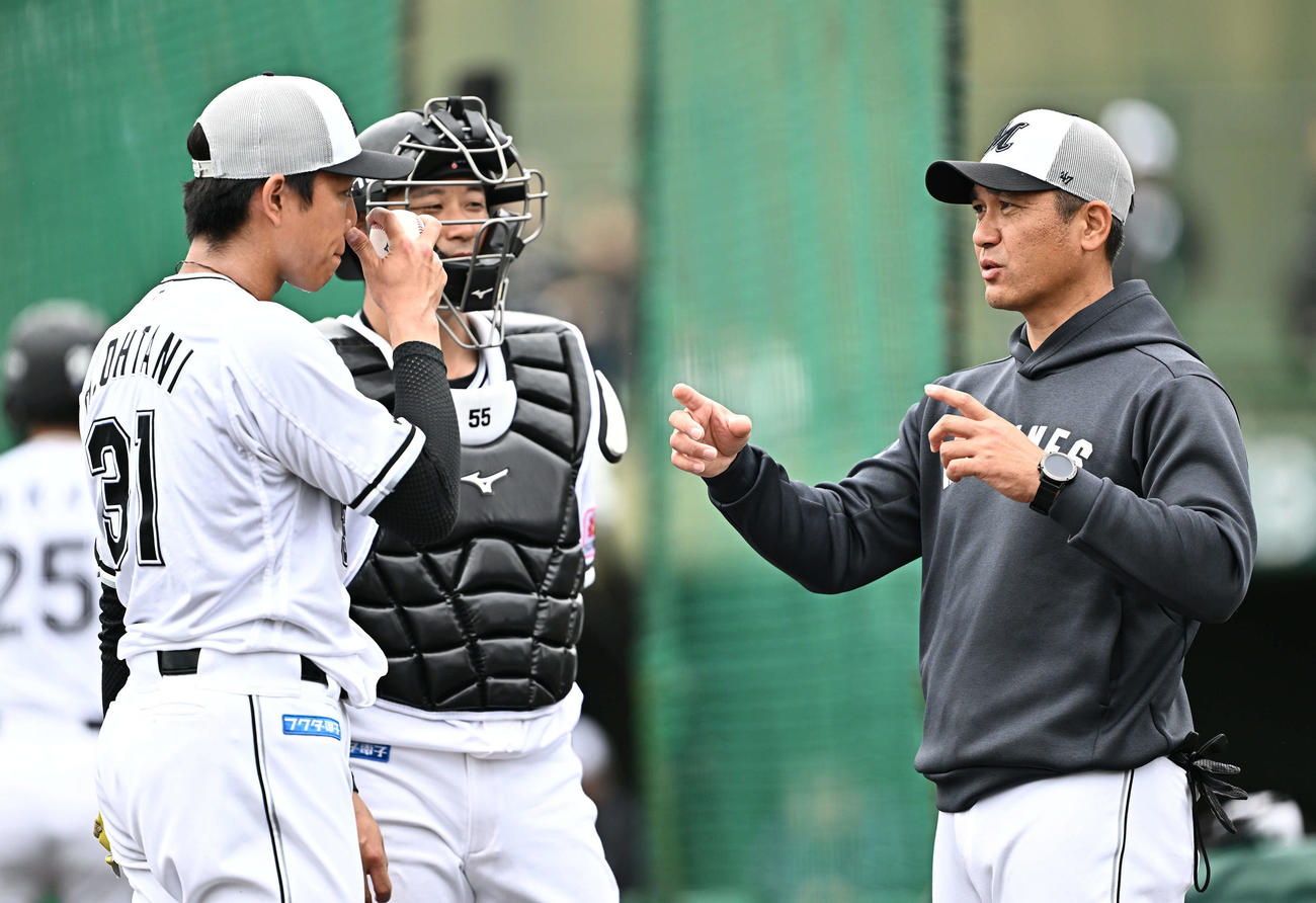 ライブBPの登板を終えたロッテ大谷（左）は黒木投手コーチ（右）と話す。捕手柿沼（撮影・滝沢徹郎）