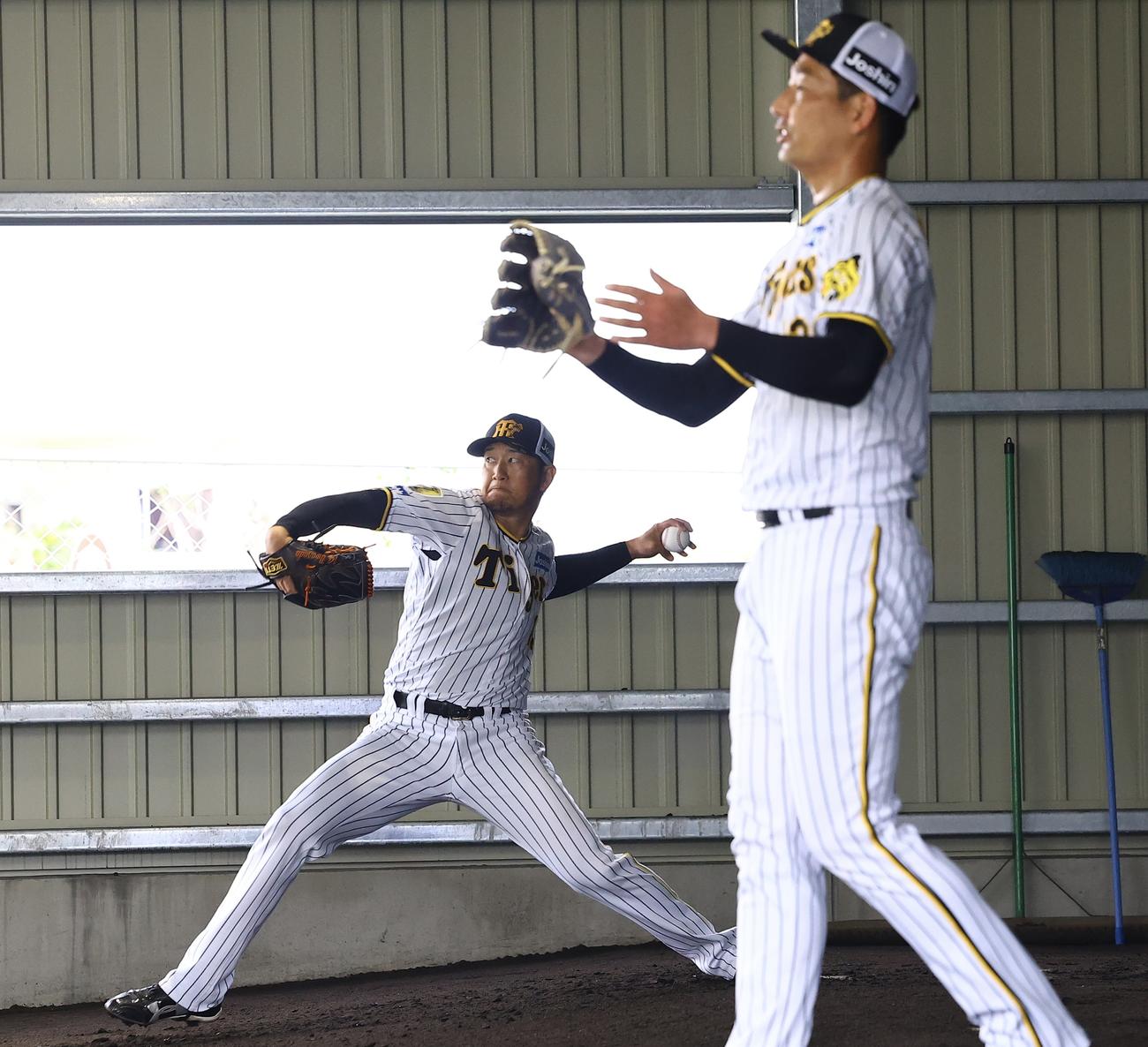 阪神2軍春季キャンプブルペンで投球練習する岩崎（右）と岩貞（撮影・藤尾明華）