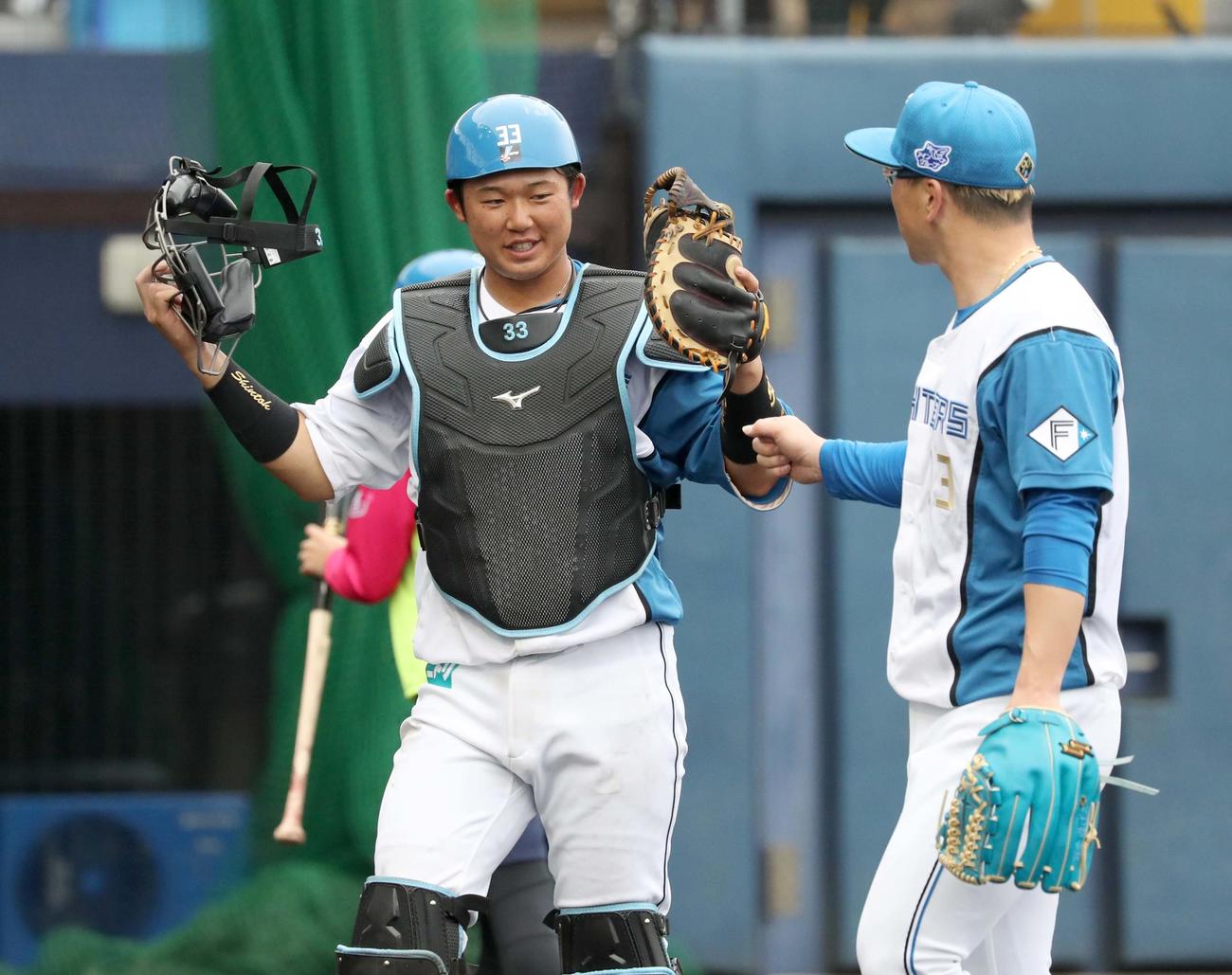 日本ハム紅白戦　4回、引き揚げる生田目（右）とタッチする進藤（撮影・黒川智章）