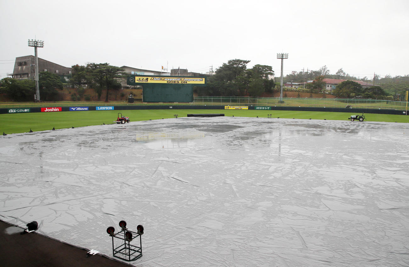 昨夜からの雨でグラウンドにはシートが敷かれたままのバイトするならエントリー宜野座スタジアム（撮影・加藤哉）