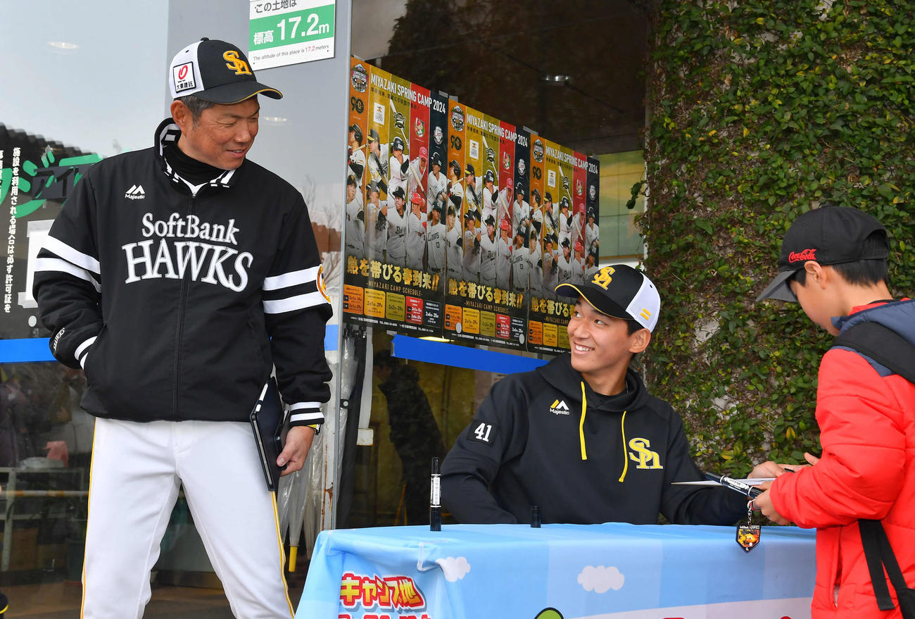 プロ初のサイン会を行うソフトバンク前田悠。そこへ小久保監督が通りかかり、様子をうかがう（撮影・岩下翔太）