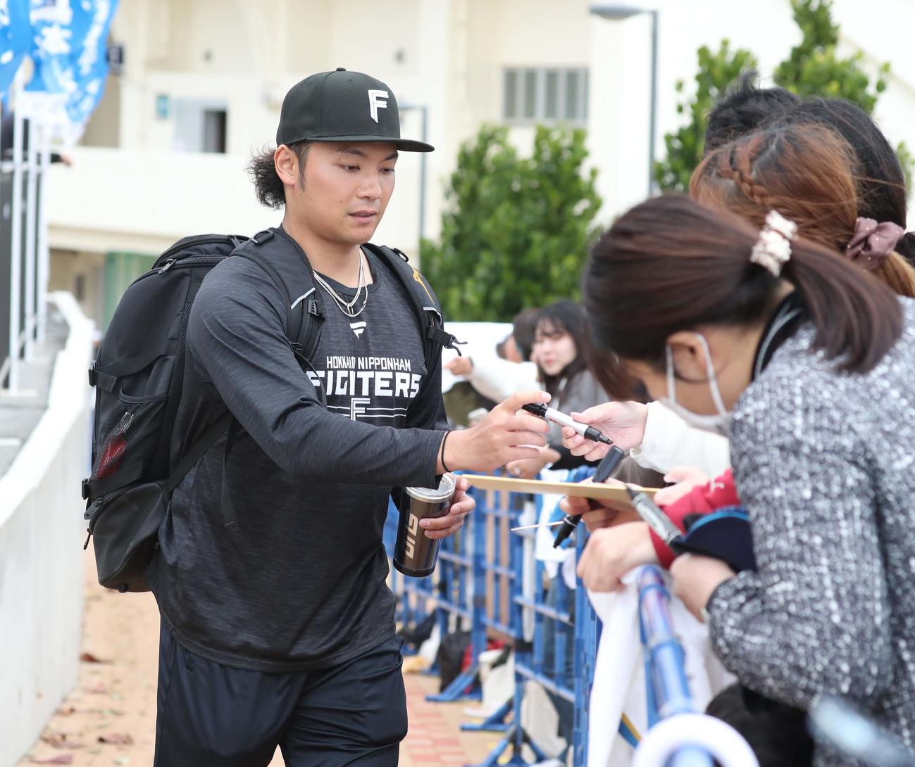 練習後、ファンにサインする日本ハム伊藤（撮影・黒川智章）