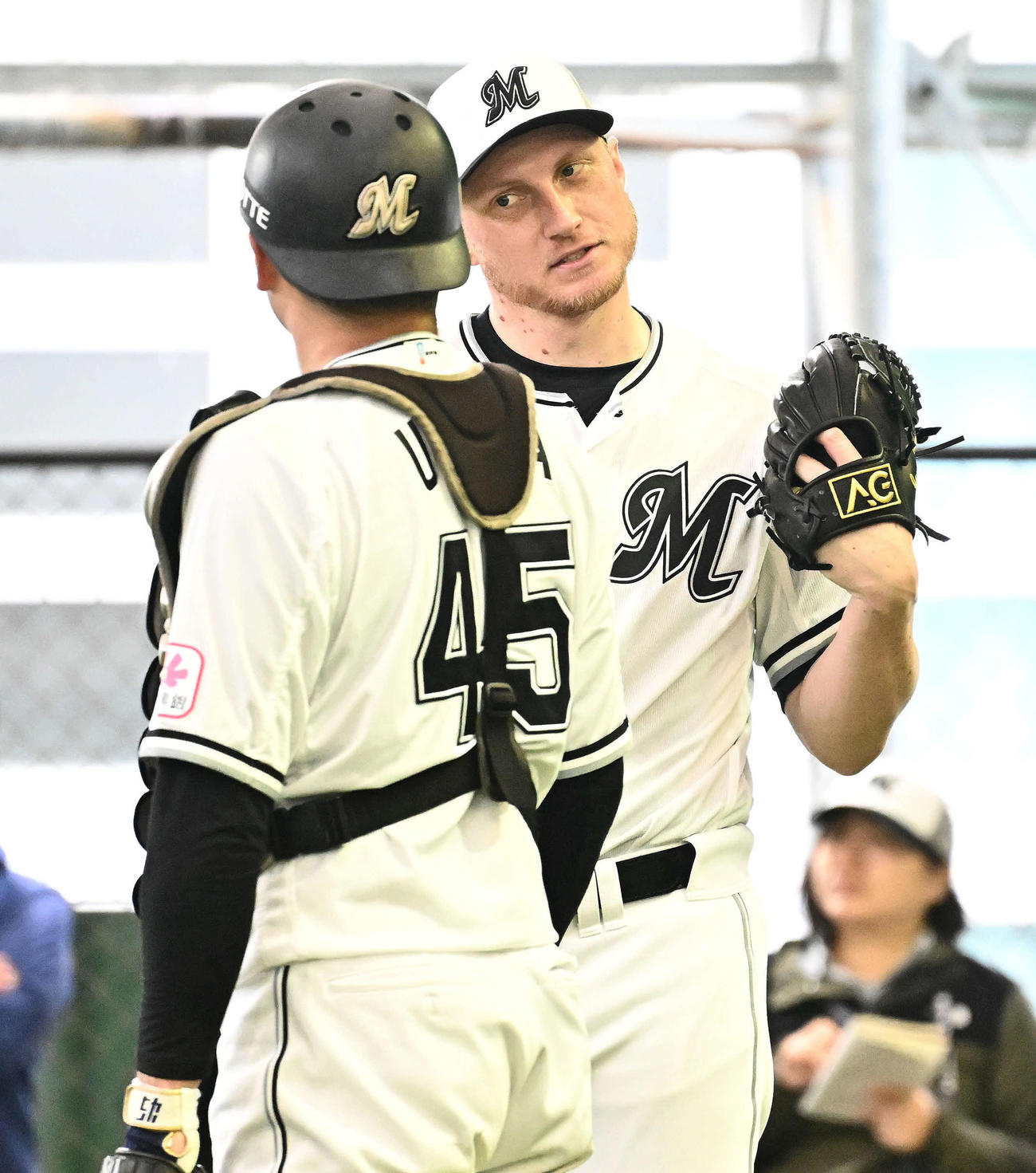 ブルペンの投球練習を終えたロッテのダイクストラ（右）は植田と話す（撮影・滝沢徹郎）