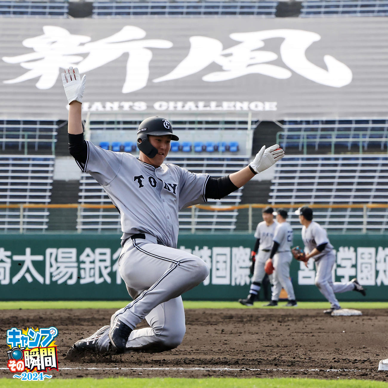 今年のスローガン「新風」を背に三塁に滑り込む巨人秋広優人（撮影・浅見桂子）