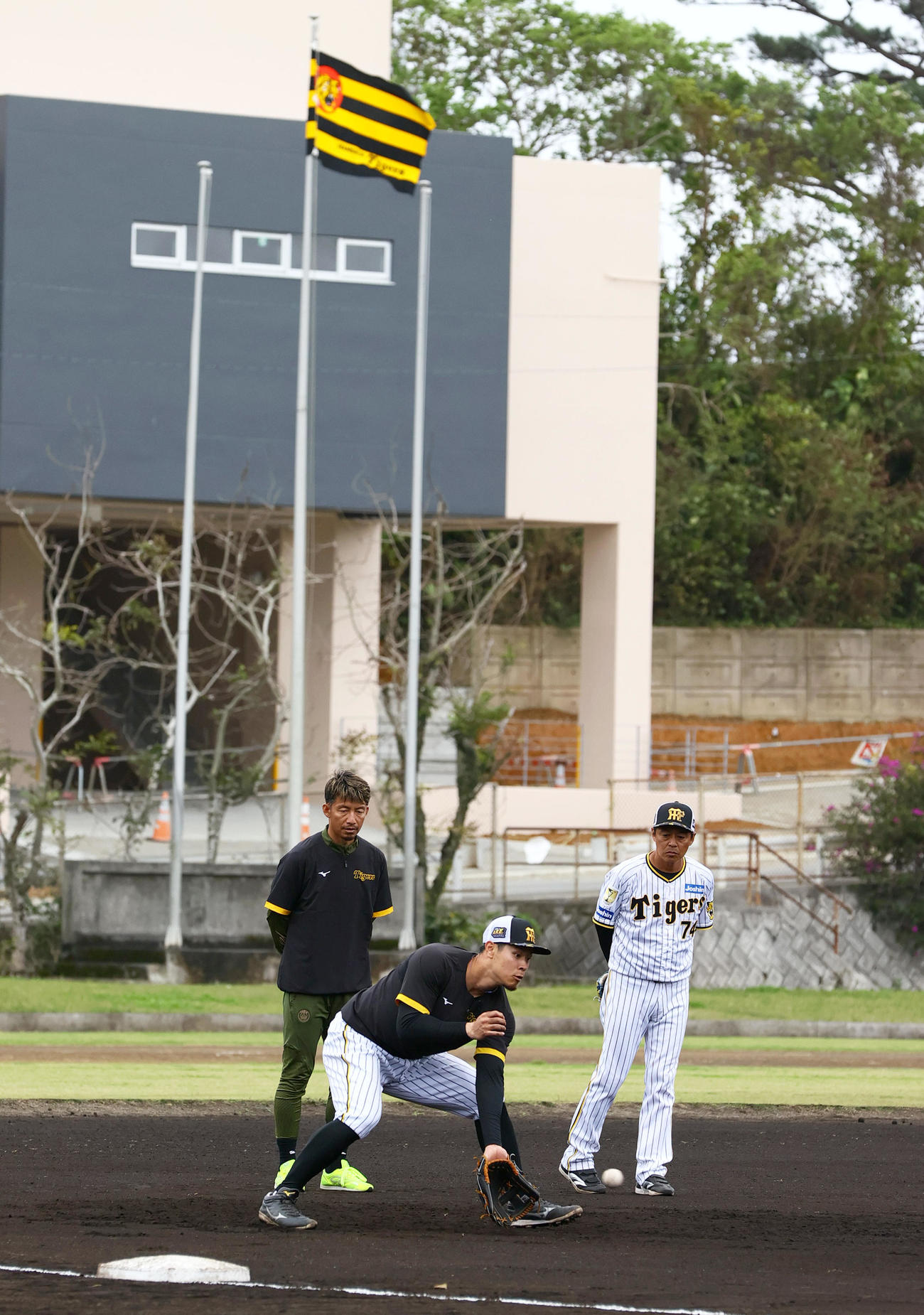 阪神佐藤輝（手前）は鳥谷臨時コーチ（左）から100分間の個別指導を受ける。右は藤本コーチ（撮影・上山淳一）