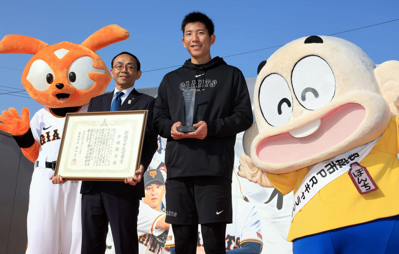 都城市市民栄誉賞を受賞した巨人戸郷（中央右）は池田市長（同左）と、ぼんち君、ジャビットと笑顔で記念撮影（撮影・浅見桂子）