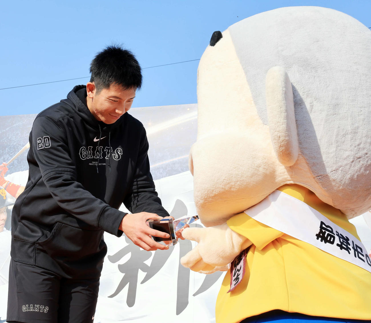 都城市市民栄誉賞を受賞した巨人戸郷（左）は受け取ったトロフィーを、ご当地キャラのぼんち君に贈呈するしぐさ（撮影・浅見桂子）