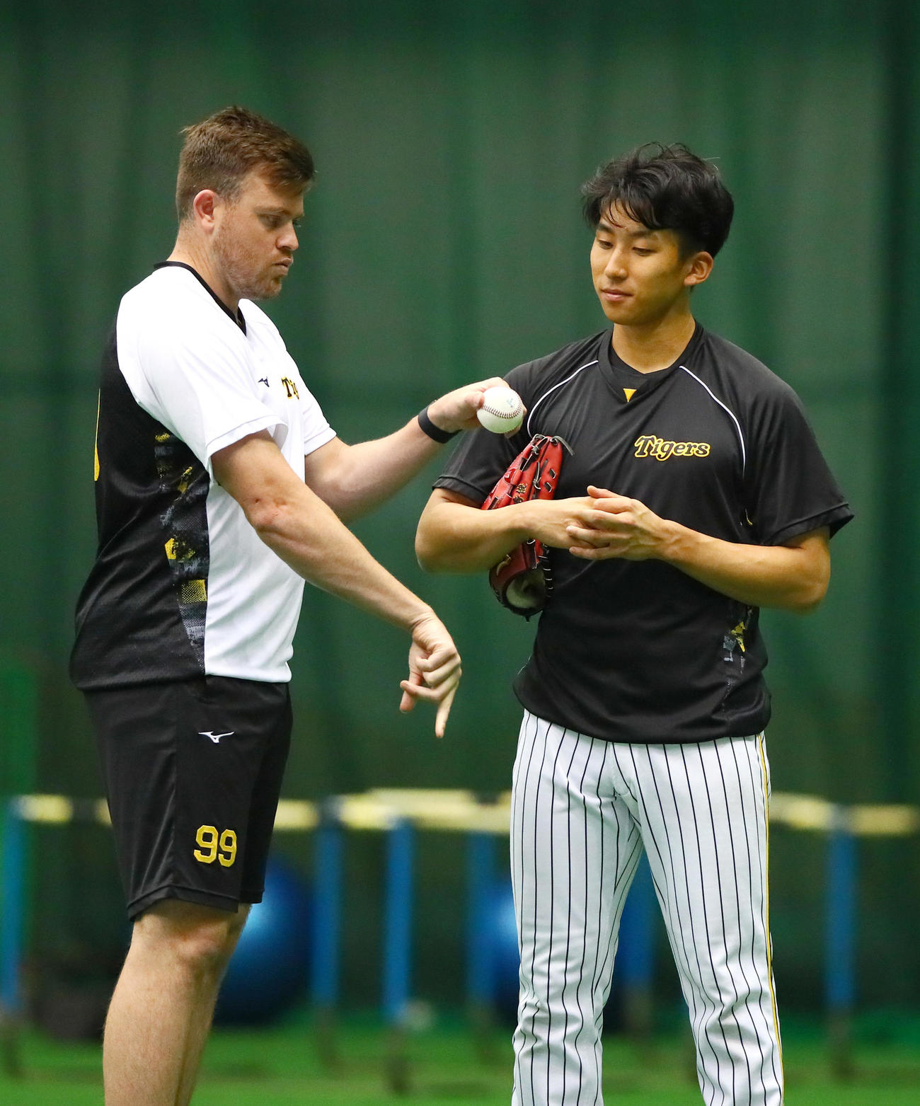 阪神ビーズリー（左）から球種を学ぶ阪神茨木（撮影・上山淳一）