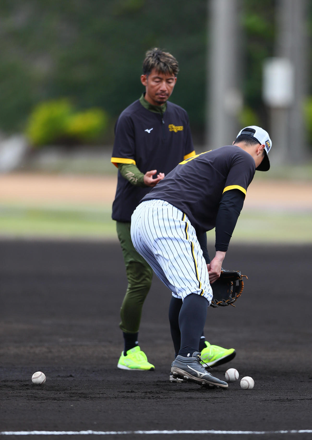 阪神佐藤輝（右）は鳥谷臨時コーチから守備の指導を受ける（撮影・上山淳一）