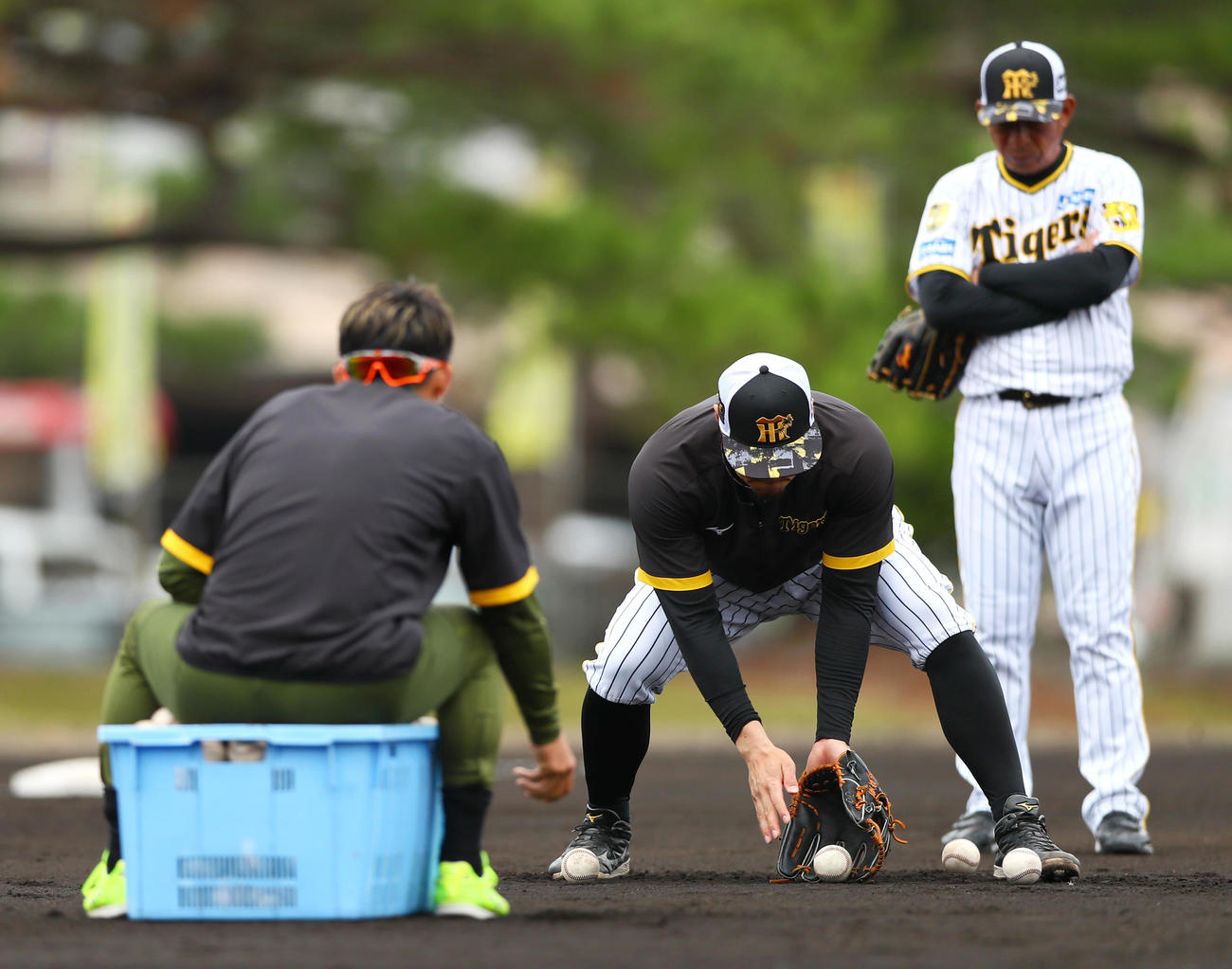 阪神佐藤輝（中央）は鳥谷臨時コーチから守備の指導を受ける。右は馬場内野守備走塁コーチ（撮影・上山淳一）