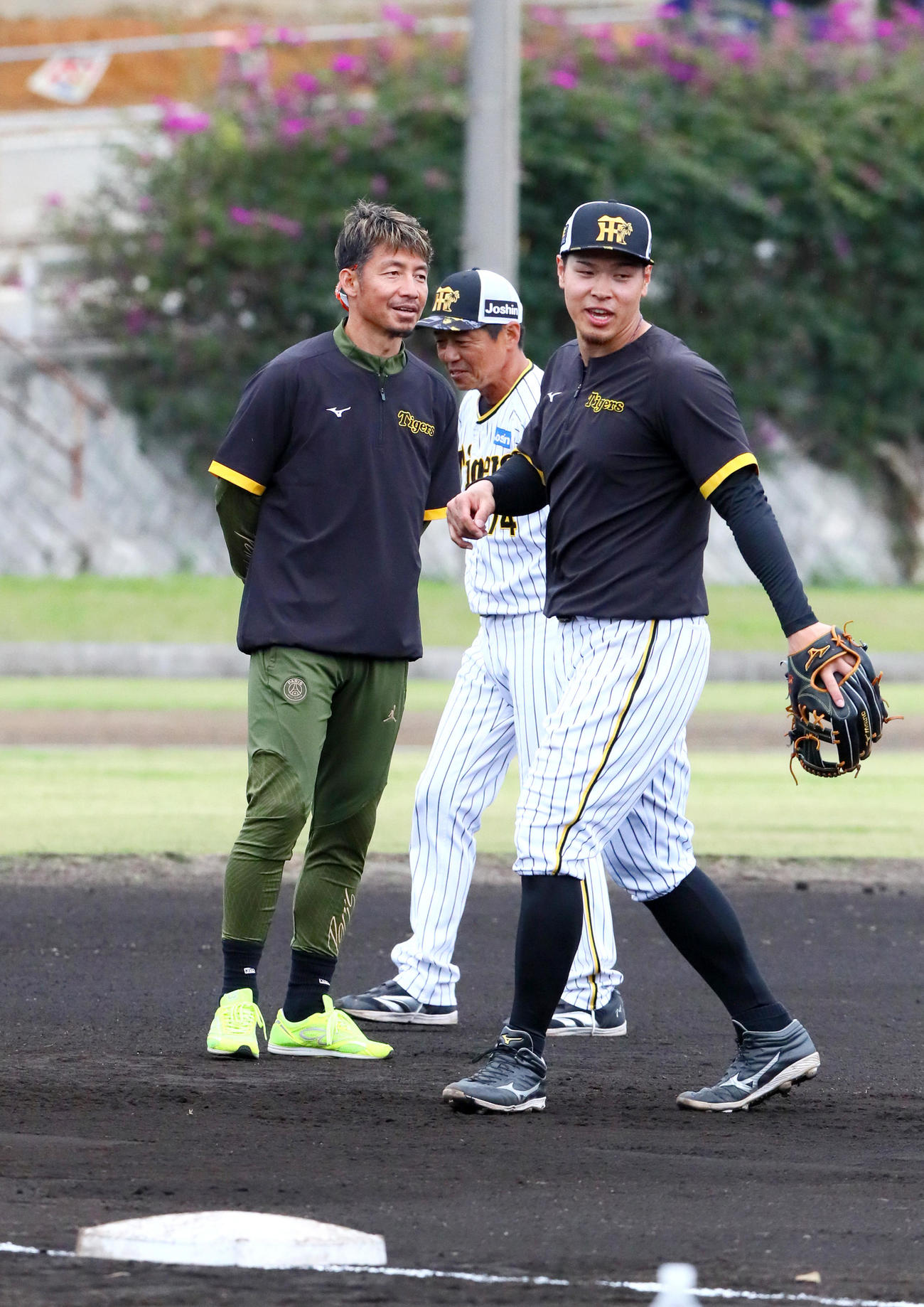 阪神佐藤輝（右）は鳥谷臨時コーチ（左）から守備の指導を受ける。中央は藤本内野守備走塁コーチ（撮影・上山淳一）