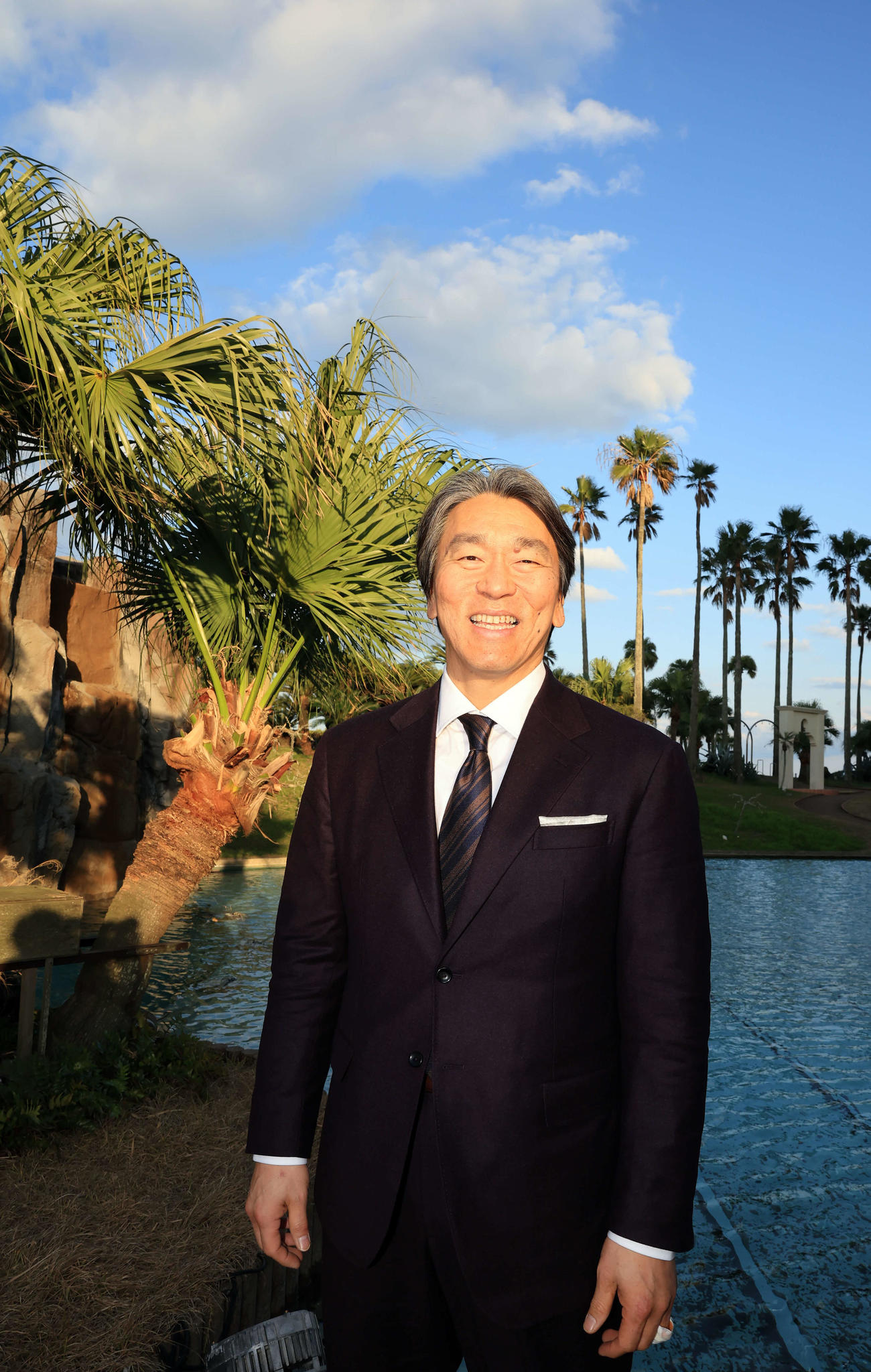 巨人の臨時コーチを務めるため宮崎入りした松井秀喜氏は、宿舎でヤシの木を背に懐かしそうに笑顔を見せる（撮影・浅見桂子）