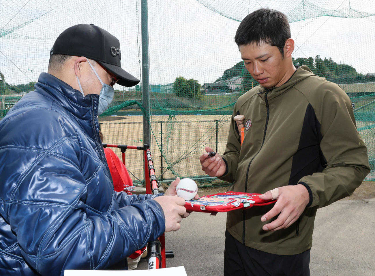 休日返上でマシン打撃練習後、待っていたファンにサインする広島中村奨（撮影・加藤孝規）