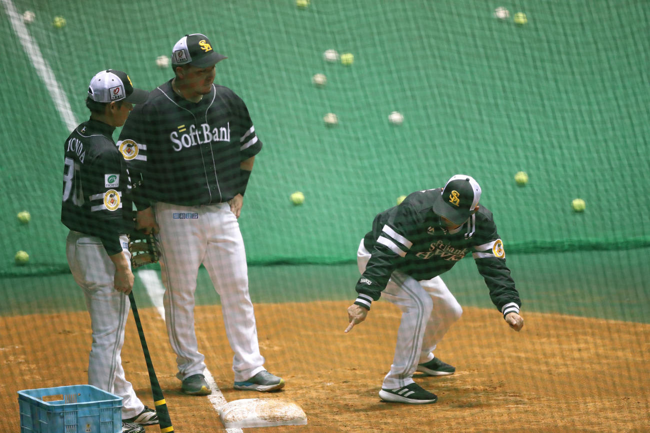 一塁の守備について山川に指導する奈良原コーチ、左は本多コーチ（撮影・梅根麻紀）