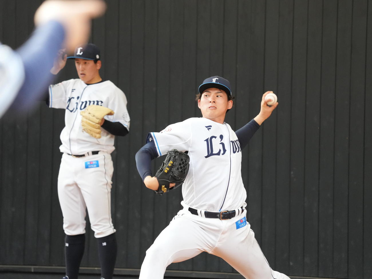 西武南郷キャンプ4日目、ブルペンでツーシームを投げる西武ドラフト1位の武内。左は隅田（撮影・小沢裕）