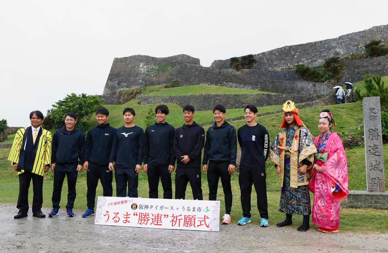キャンプ休日で勝連城跡を訪れ記念写真に納まる、左から中村正人うるま市長、福島、松原、津田、石黒、百崎、山田、下村、阿麻和利役、百十踏揚役（撮影・上山淳一）