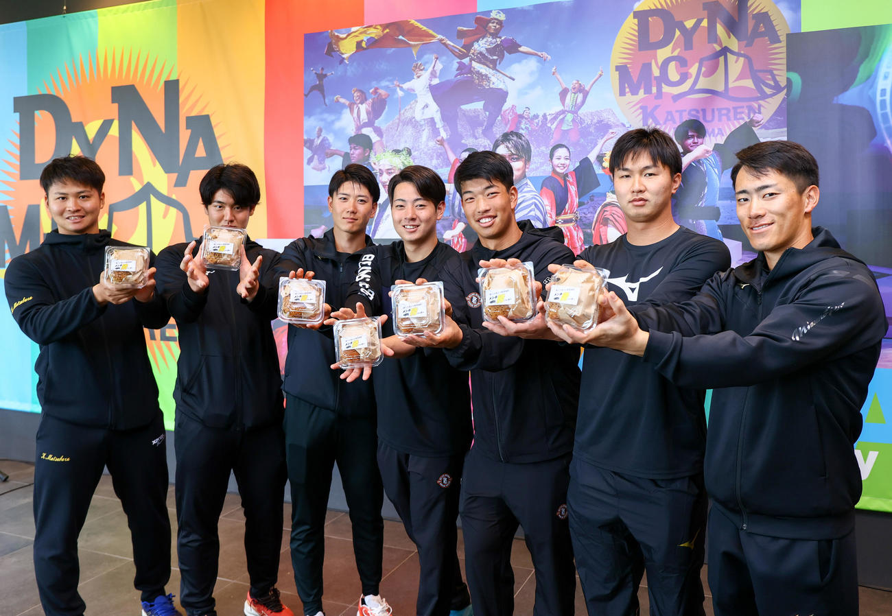 「メンチ勝バーガー」を手に笑顔を見せる、左から阪神松原、石黒、山田、下村、百崎、津田、福島（撮影・上山淳一）