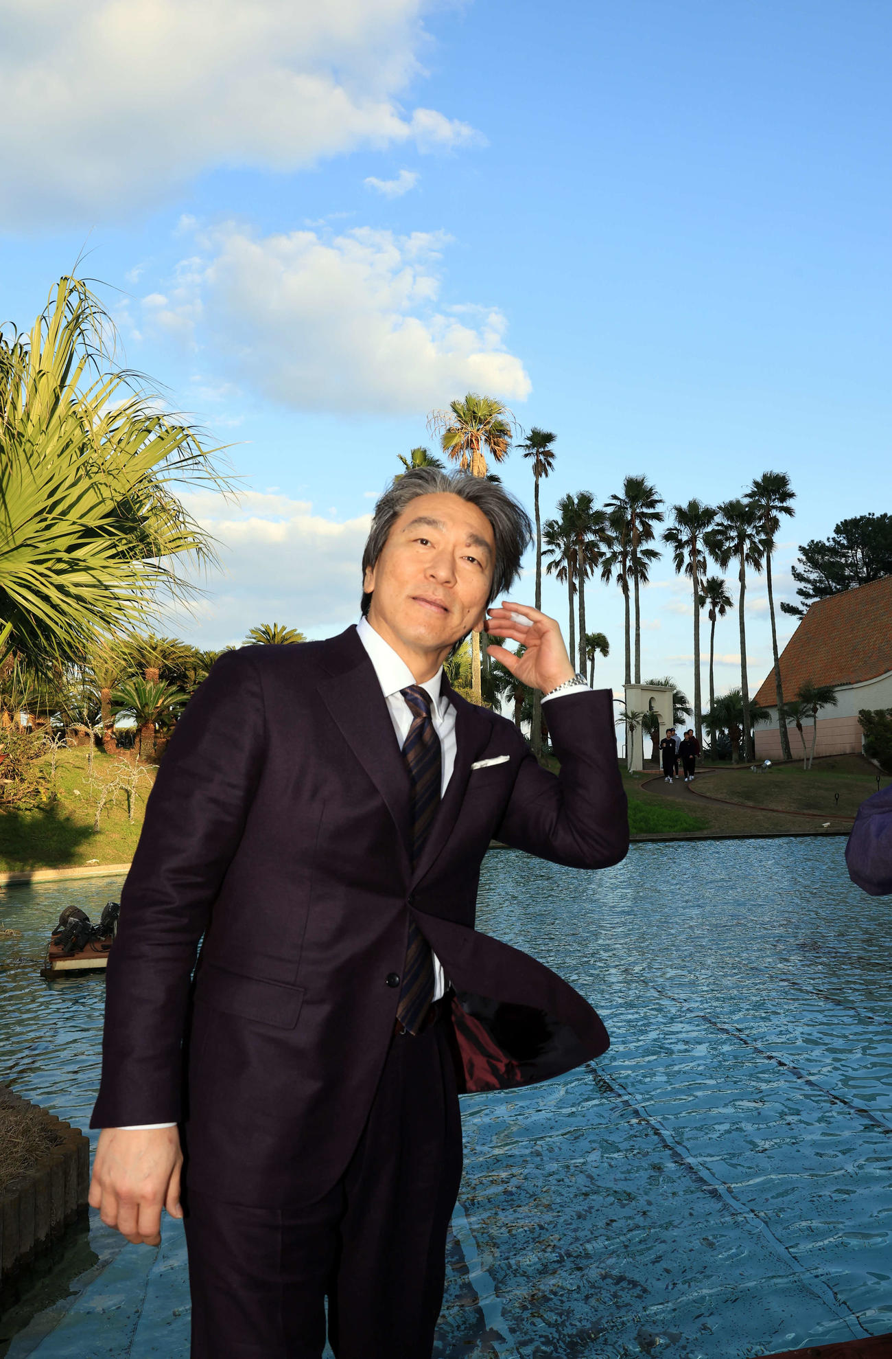 巨人の臨時コーチを務めるため宮崎入りした松井秀喜氏は、選手宿舎でヤシの木を背に風にあたる（撮影・浅見桂子）