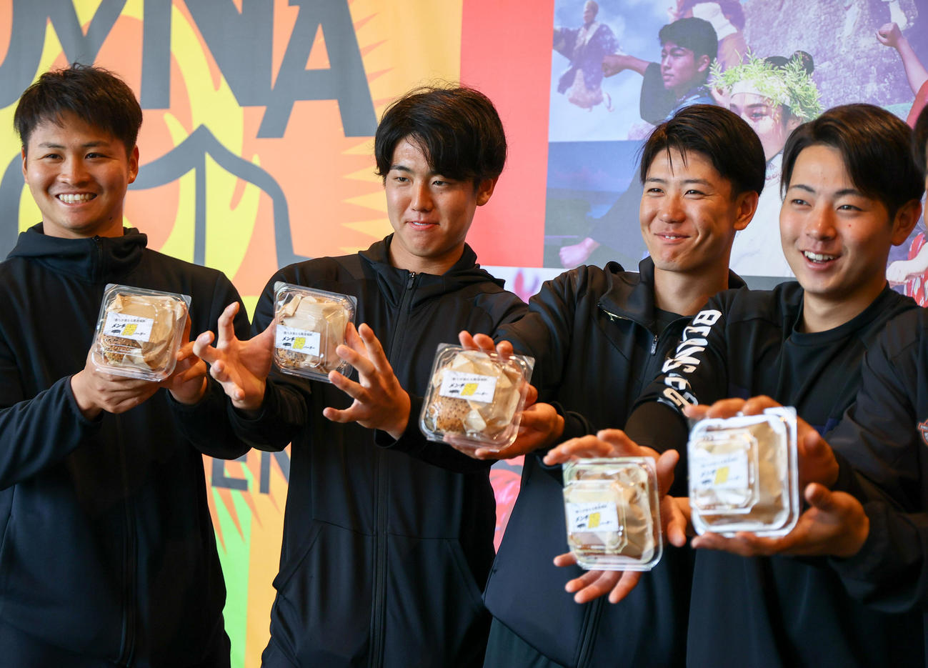 「メンチ勝バーガー」を手に笑顔を見せる、左から松原、石黒、山田、下村（撮影・上山淳一）