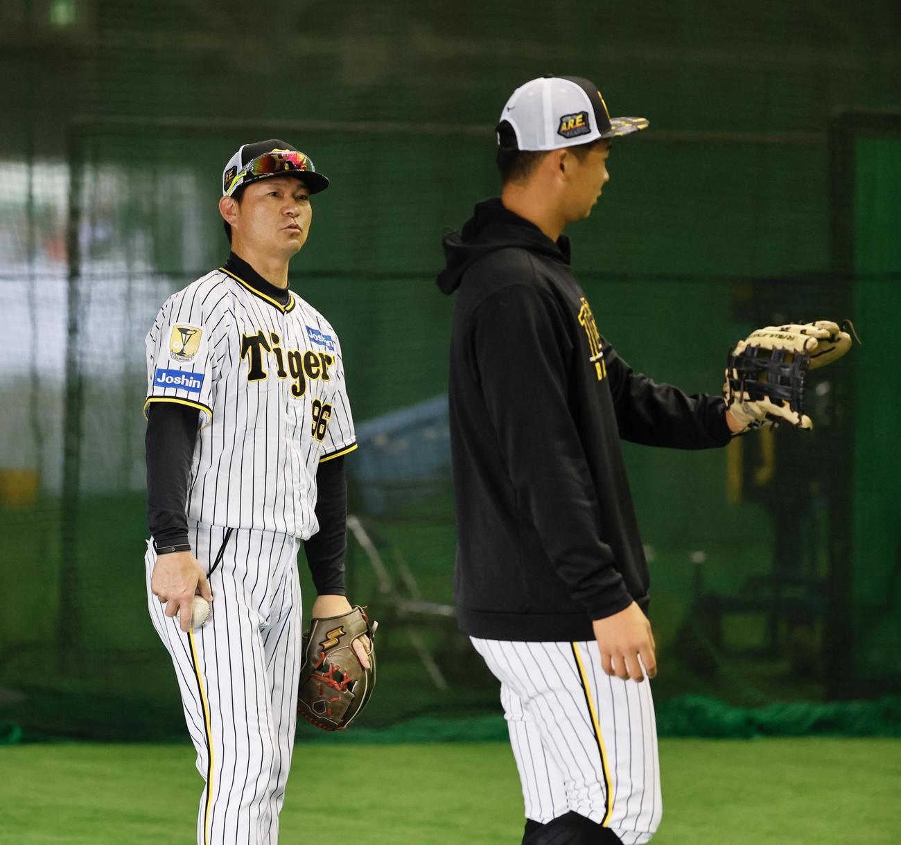 阪神春季キャンプ　キャンプに合流し、早出で井上（右）を指導する筒井外野守備走塁コーチ（撮影・藤尾明華）