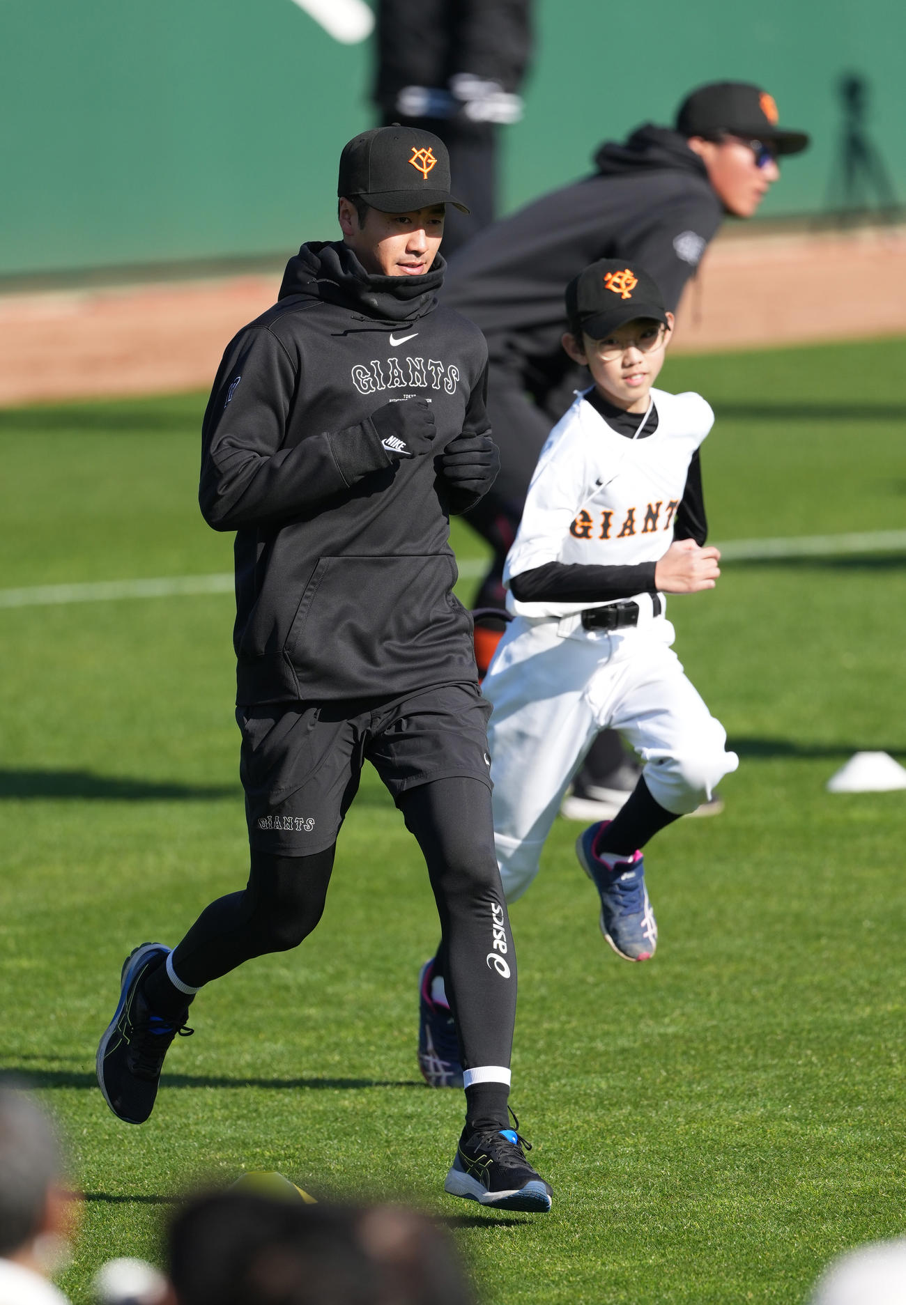 野球少年と一緒にアップする巨人西舘（撮影・鈴木みどり）