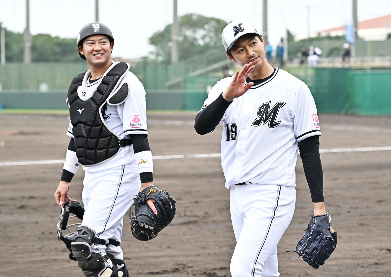 ライブBPの登板を終えたロッテ唐川（右）は観客席に手を振り引き上げる。捕手佐藤（撮影・滝沢徹郎）