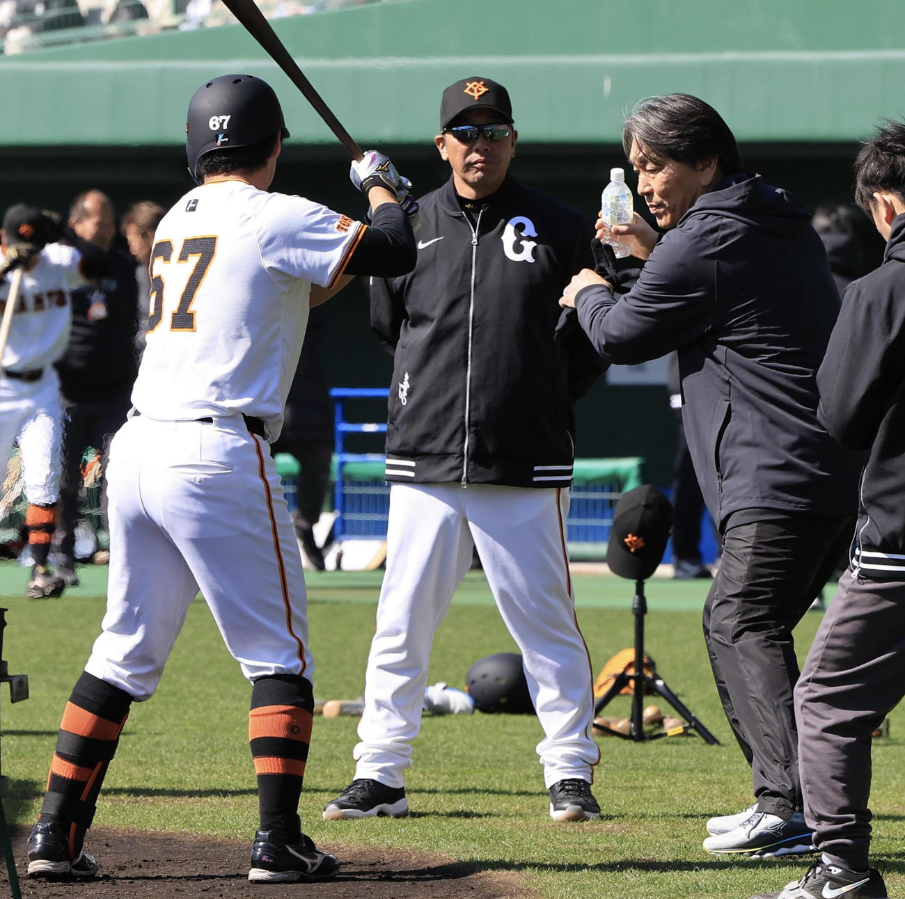 巨人の臨時コーチの松井秀喜氏(右)から打撃指導される山瀬。中央は阿部監督