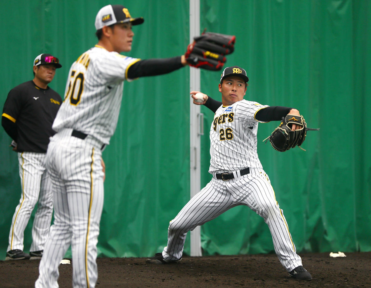 ブルペンで投げる椎葉。手前は富田。左は安藤投手コーチ（撮影・上山淳一）