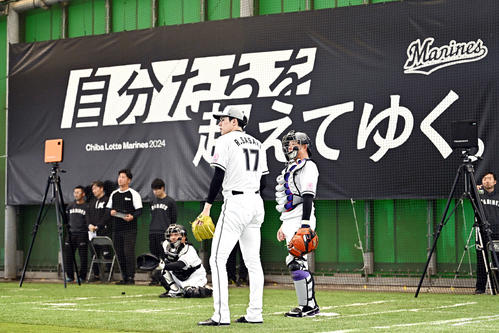 ブルペン投球を終えたロッテ佐々木（左）は味園ブルペン捕手と話す（撮影・滝沢徹郎）